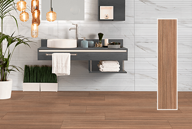 CERÁMICA MADERADA CAFÉ ROVERE MEL 25X115CM Cerámica maderada café clara en baño pisos y parede revestimiento cerámico blanco con betas, un meson gris con un lavamanos blanco y grifo dorado alto, plantas decorativas.