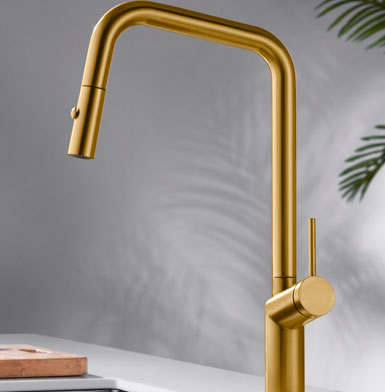 griferia-BONN-ORO-ROSA-CEPILLADO Llave de cocina elegante color dorada tipo oro, con mango extraible de fondo pared blanca con reflejo de hojas verdes