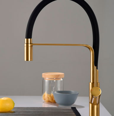 griferia-SENA-ORO-CEPILLADO Llave para cocina dorada con negro con manivela para agua fria y caliente, diseño en tendencia curvo, limon amarillo y fondo blanco, accesorios de cocina